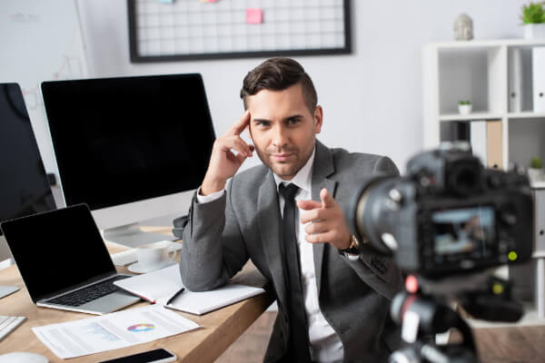 A business man is pointing its finger to the recording camera