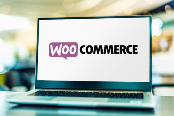 A laptop screen with the WooCommerce plugin logo