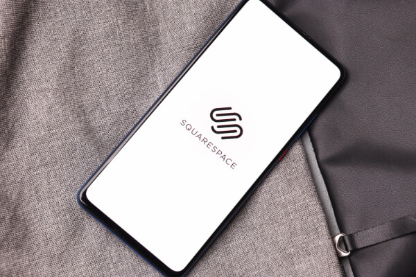 A smartphone background is showcasing the Squarespace's logo