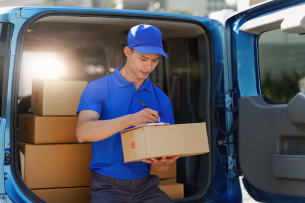 A delivery courier is picking up a package