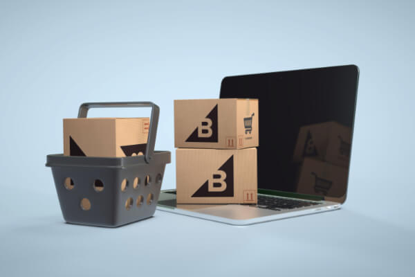 A laptop screen and a cart showing packages with BigCommerce logo