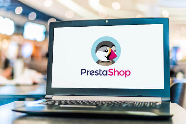 A laptop screen is showing Prestashop's logo