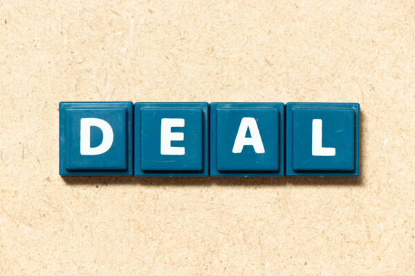 Blue letter blocks spelling the word "DEAL" on a neutral background, representing successful AI-assisted sales negotiation and closing.