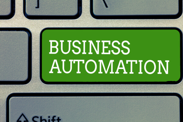 A close-up of a computer keyboard featuring a large, bright green key with the white text BUSINESS AUTOMATION.